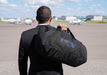 man holding faraday duffel bag at the airport