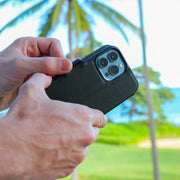 DefenderShield SlimFlip® iPhone 13 Series 5G EMF Phone Case being used in an outdoor setting